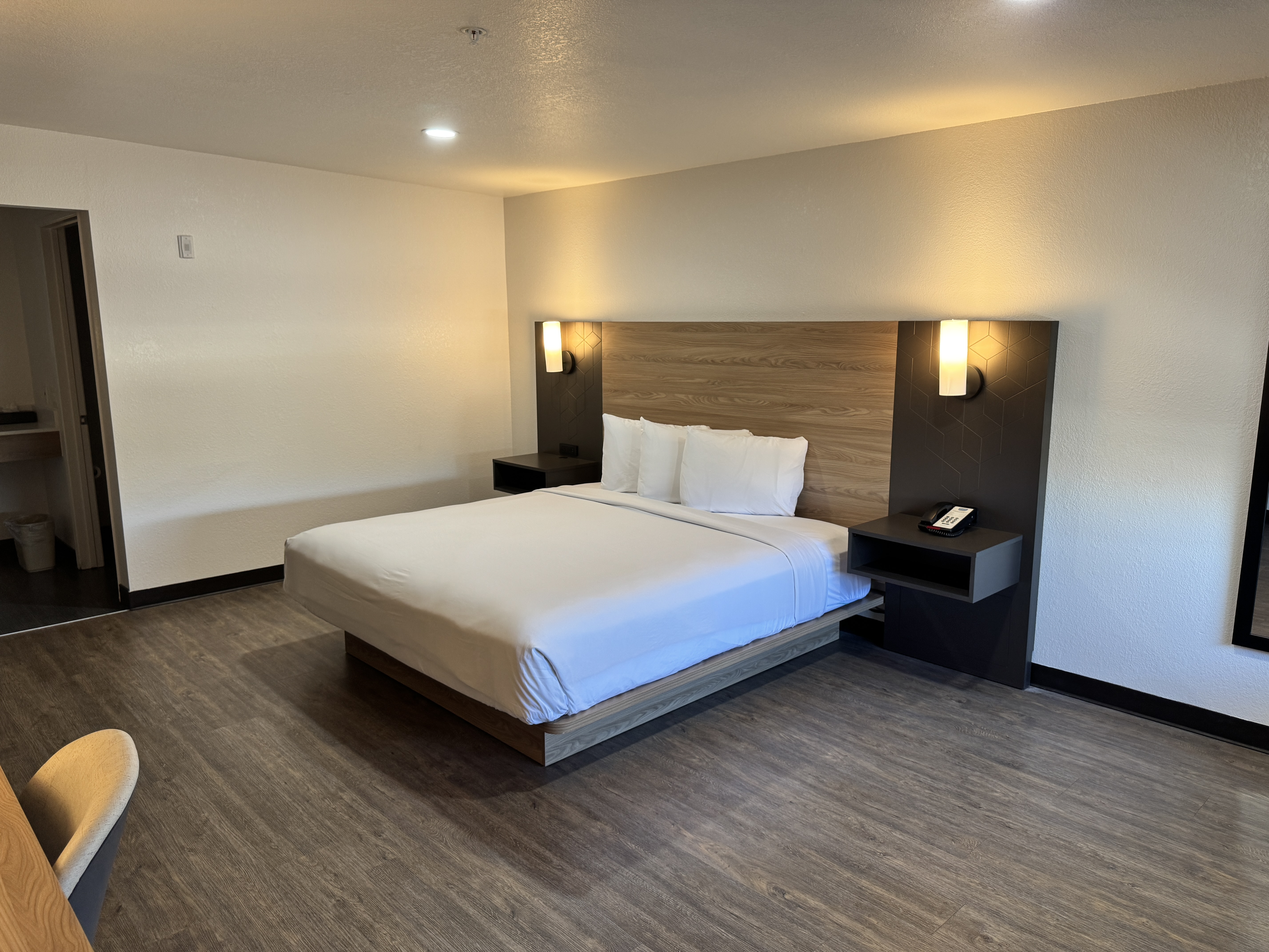 Queen room with desk, television, and vanity area
