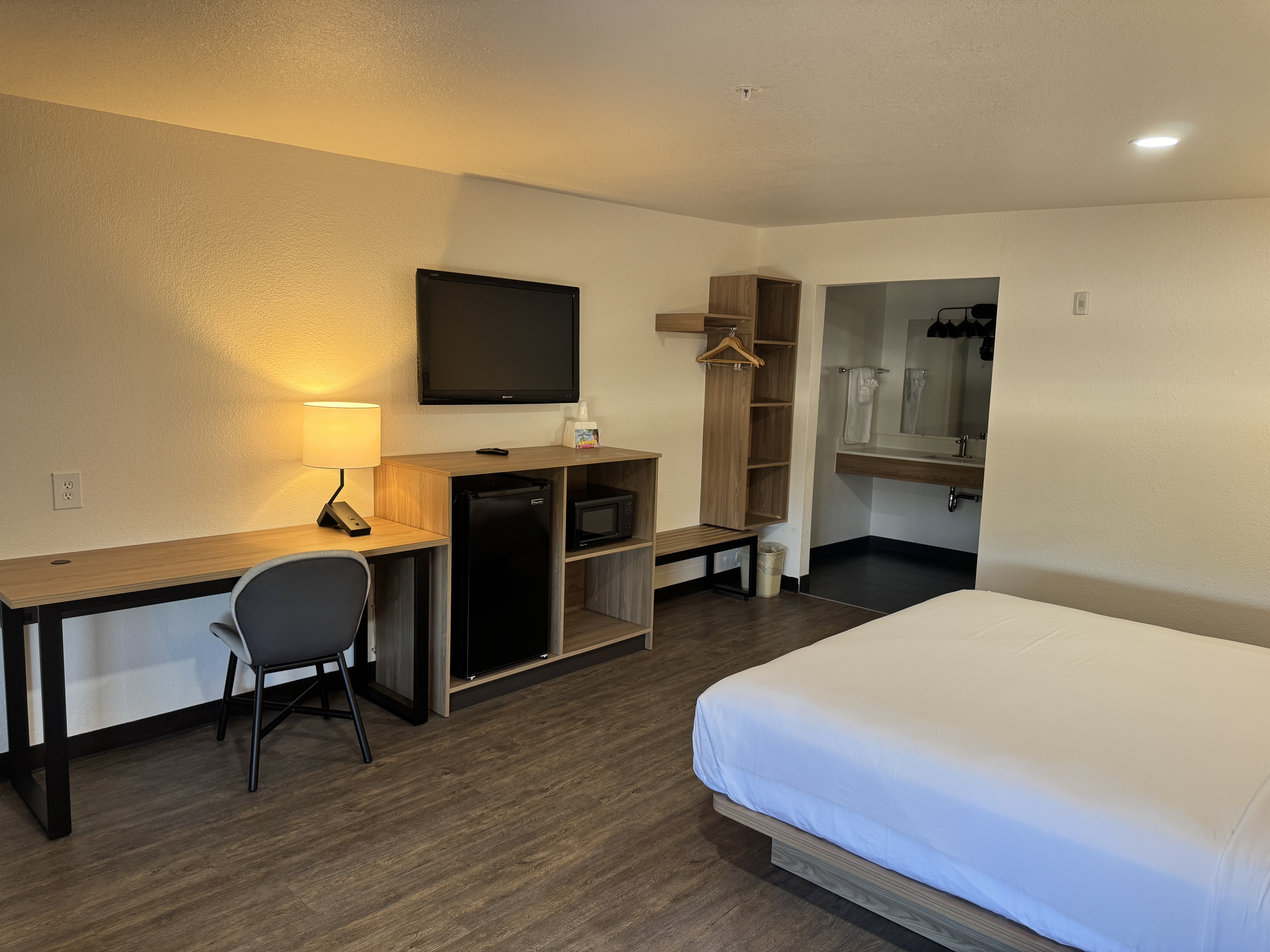 Queen room with desk, television, and luggage area